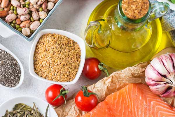 Eine Auswahl gesunder Lebensmittel wie Lachs, Leinsamen, Bohnen, Öl, Knoblauch und Tomaten, die eine zuckerfreie Ernährung unterstützen. Eine Auswahl gesunder Lebensmittel wie Lachs, Leinsamen, Bohnen, Öl, Knoblauch und Tomaten, die eine zuckerfreie Ernährung unterstützen.