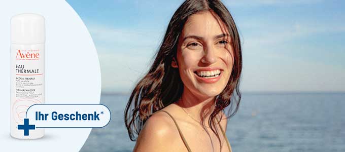 Avène Thermalwasserspray mit Hinweis „Ihr Geschenk*“ und eine glücklich lachende Frau vor dem blauen Meer. Avène Thermalwasserspray mit Hinweis „Ihr Geschenk*“ und eine glücklich lachende Frau vor dem blauen Meer.