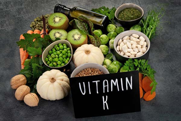 Verschiedene Lebensmittel, die VItamin K enthalten; z.B.: Kiwis, Rosenkohl, Walnüsse