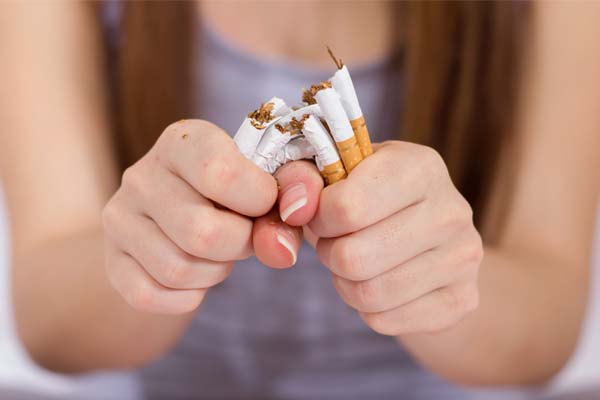 Eine Frau zerdrückt ihre Zigaretten, weil sie mit dem Rauchen aufhören will.