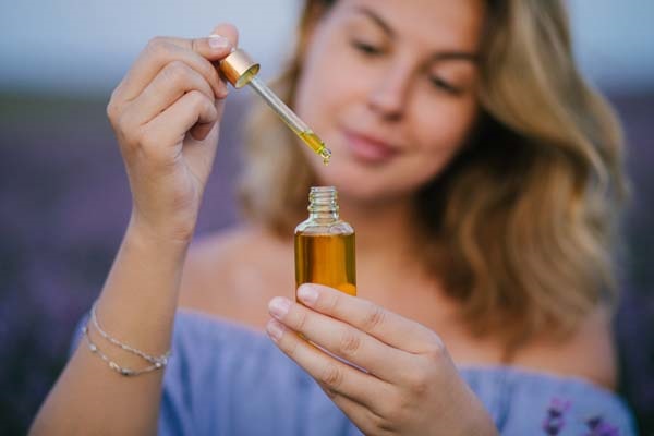 Eine Frau testet ein ätherisches Öl zur Aromatherapie.