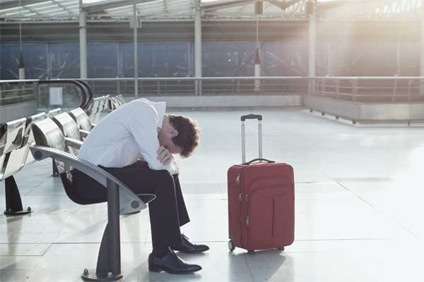 Ein Mann am Flughafen leidet unter einer Reisekrankheit mit Übelkeit