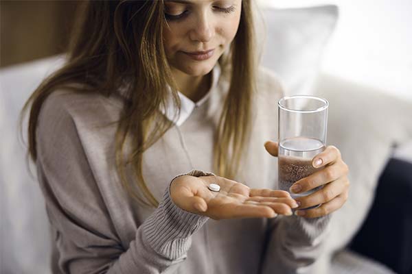 Frau hält Tablette und Glas Wasser in den Händen. Frau hält Tablette und Glas Wasser in den Händen.