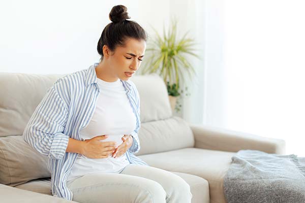 Frau hält sich mit Schmerzen den Bauch. Frau hält sich mit Schmerzen den Bauch.