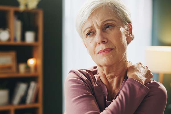 Ältere Frau hält sich mit Schmerzen die Schulter. Ältere Frau hält sich mit Schmerzen die Schulter.