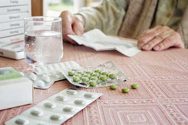 Tabletten und Glas Wasser liegen auf einem Tisch. Tabletten und Glas Wasser liegen auf einem Tisch.